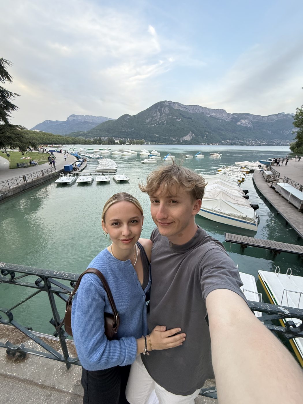 Selfie au bord du lac d'Annecy en fin de journée, montagnes derrière.