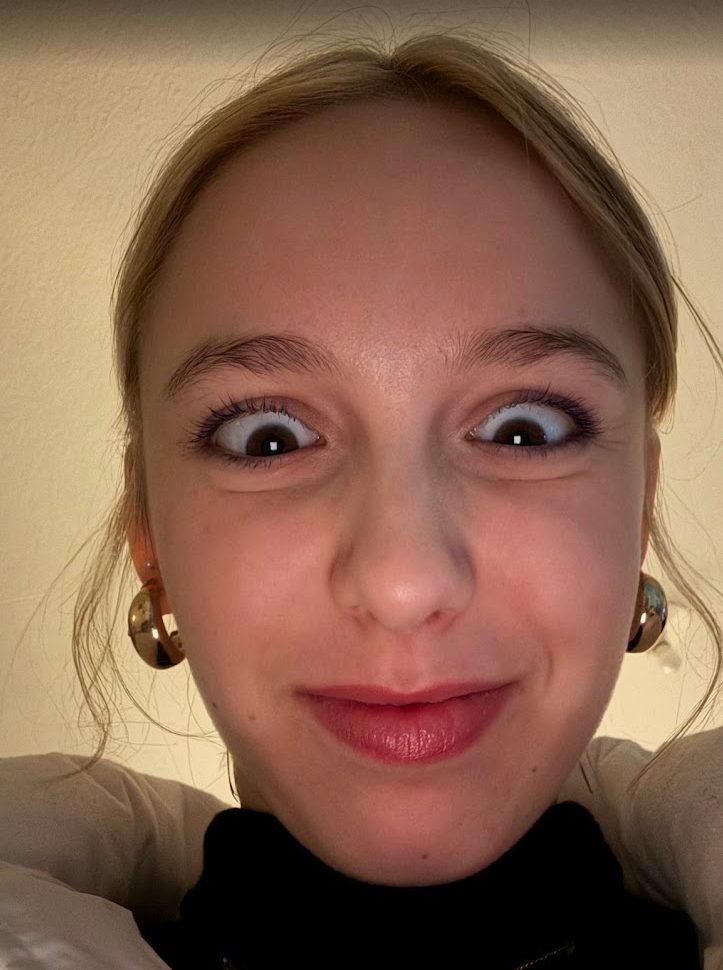 Gros plan sur son visage faisant une grimace, les yeux exorbités.